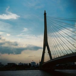 View of suspension bridge against cloudy sky