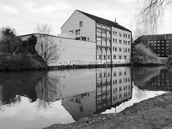 Reflection of building on lake against sky