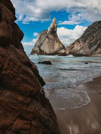 Scenic view of rocks in sea against sky