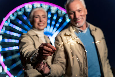 Smiling young man holding hands at night