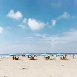 People on beach against blue sky