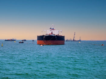 Ship sailing in sea against clear sky