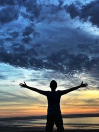 Silhouette man standing against sky at sunset