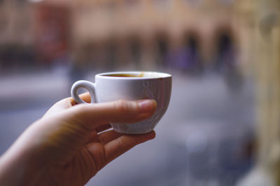 Close-up of hand holding coffee cup