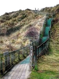 Steps leading towards sea against clear sky