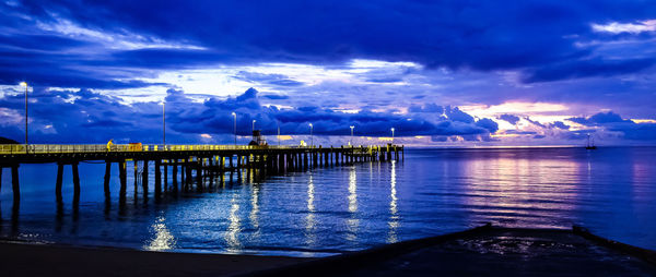 Pier on sea against cloudy sky