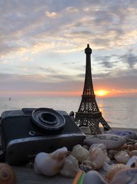 View of tower against sea during sunset