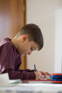 Side view of boy studying at home