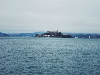 Scenic view of sea by buildings against sky