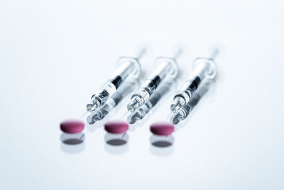 Syringes and tablets on white background, covid-19 corona virus vaccine and medicine