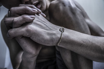 Cropped image of naked man with hands clasped