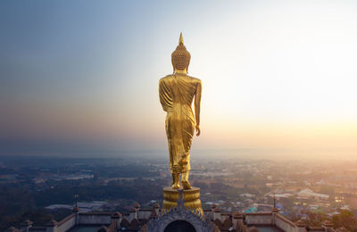 Statue of historic building against sky at sunset