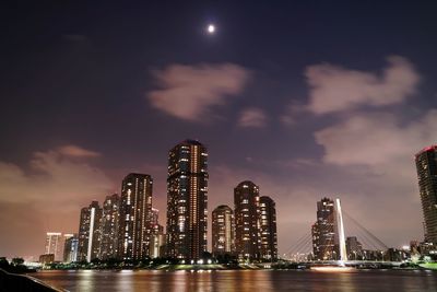 Illuminated skyscrapers by sumida river at night