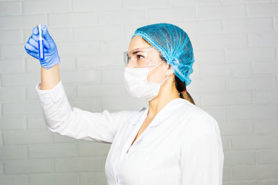 Scientist wearing mask holding test tube