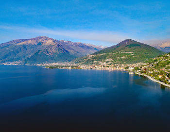 Scenic view of lake and mountains against blue sky