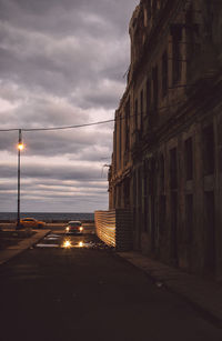 Street amidst buildings against sky at dusk