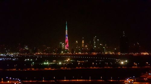 Illuminated city against sky at night