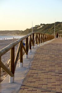 Pier over sea against clear sky during sunset