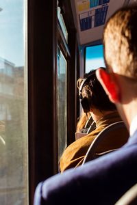 Rear view of man and woman seen through train window