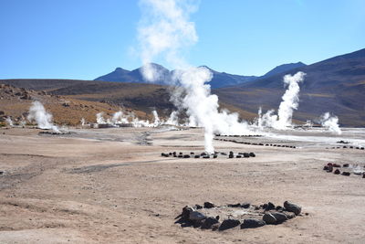 Geysers on landscape against clear sky