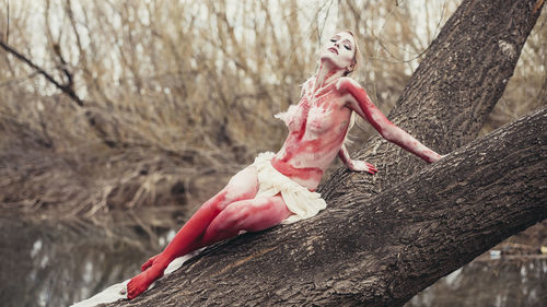 Woman leaning on tree trunk