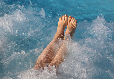 Low section of woman swimming in pool