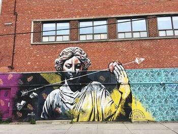 Statue against graffiti wall