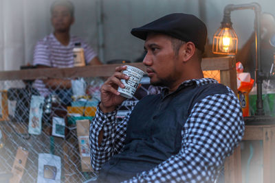 Man drinking coffee in disposable cup 