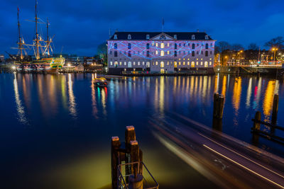 Illuminated buildings by river at night
