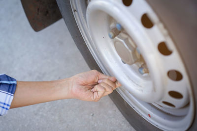 Cropped hand of manual worker examining car tire