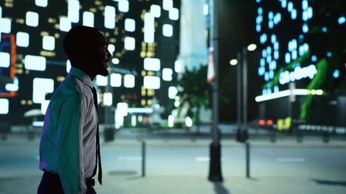 Rear view of woman walking on street at night