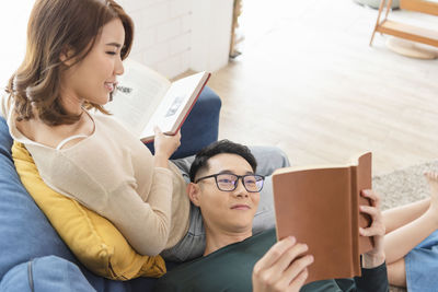 Beautiful young woman sitting on book