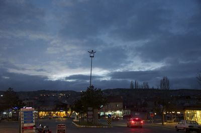 Cars on road against cloudy sky