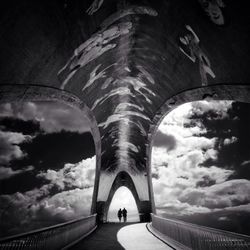 Low angle view of bridge against cloudy sky