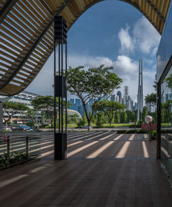 Road by trees against sky in city