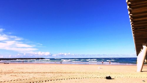 Scenic view of beach against blue sky