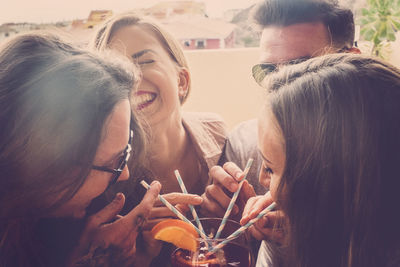 Friends having drink while sitting at table