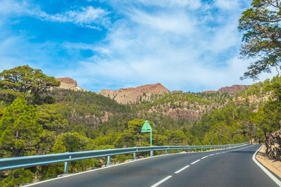 Road by mountains against sky