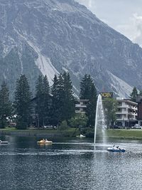 Fountain in lake against mountain