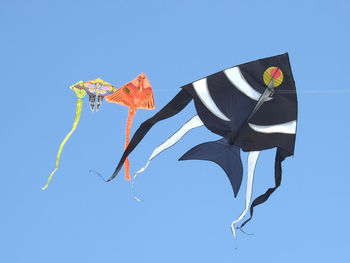 Low angle view of kite against clear blue sky