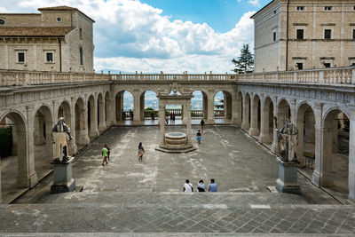 People at historic building against sky