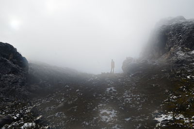 People on mountain against sky during winter