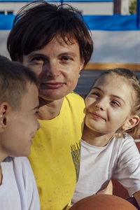 Outdoor hugs, mother and teenage children cuddle gently in the sun