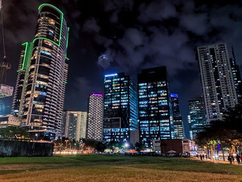 Low angle view of illuminated buildings against sky at night