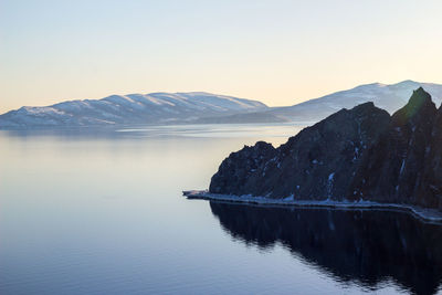 Scenic view of lake and mountains against clear sky