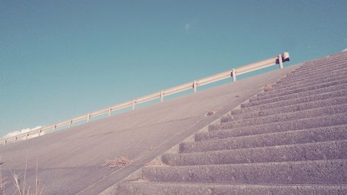 Low angle view of staircase against clear blue sky