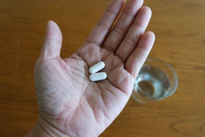 Close-up of hand holding leaf on table