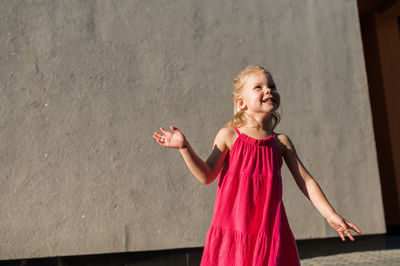 Young woman standing against wall