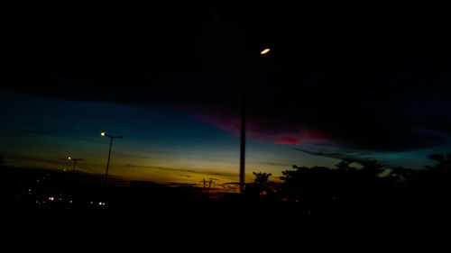 Silhouette trees against sky at night