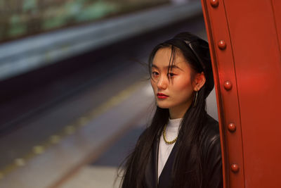 Modern asian woman at underground station, fashion portrait of trendy korean girl in casual outfit